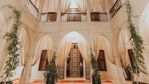 A spacious atrium with high ceilings, ornate iron railings, and a central archway. - Riad El Hara (Marrakech)