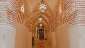 A corridor with arched brick ceilings and a central chandelier. - Riad El Hara (Marrakech)