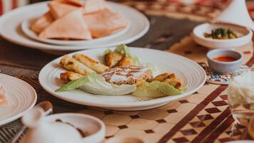 Et bord med tallerkener med mad, blandt andet sandwiches og pommes frites, samt små skåle med saucer.