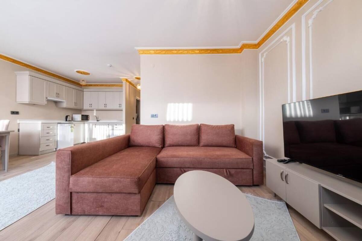 A modern living room with a sectional sofa, a flat-screen TV, and a minimalist coffee table.