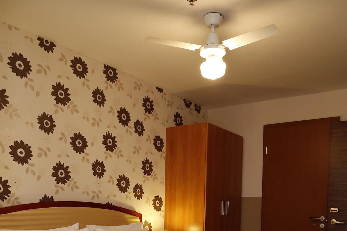 Ein Schlafzimmer mit Bett, einem Holzschrank, einem Schreibtisch und einem Stuhl.