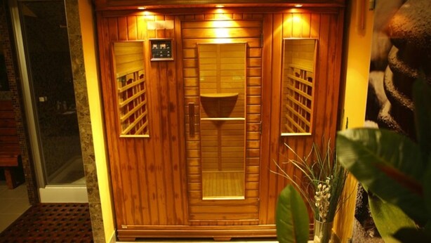 A wooden sauna with a control panel, a bench, and a small shelf. - Six Inn Hotel (Budapest)