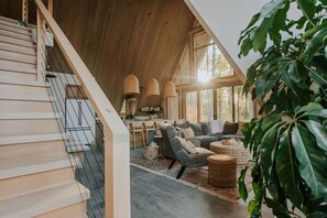 A modern interior with a staircase, seating area, and large windows.