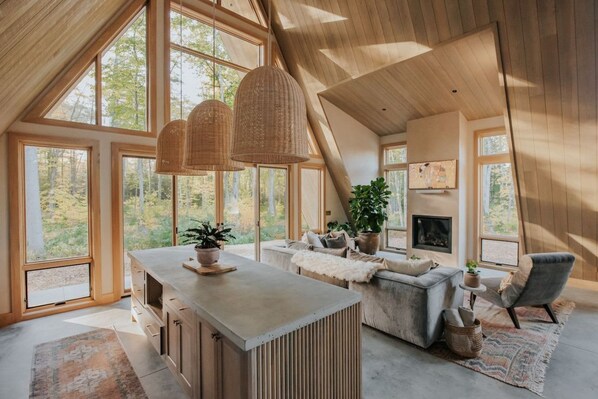 A spacious loft with large windows, a fireplace, and a cozy seating area.