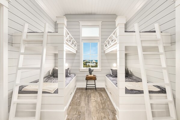 A room with bunk beds, a small table, and a window with a view.
