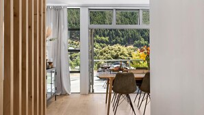Ein Essbereich mit Blick auf eine bewaldete Landschaft durch große Fenster.