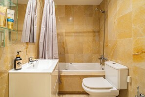 Une salle de bain avec une baignoire, des toilettes et un lavabo.