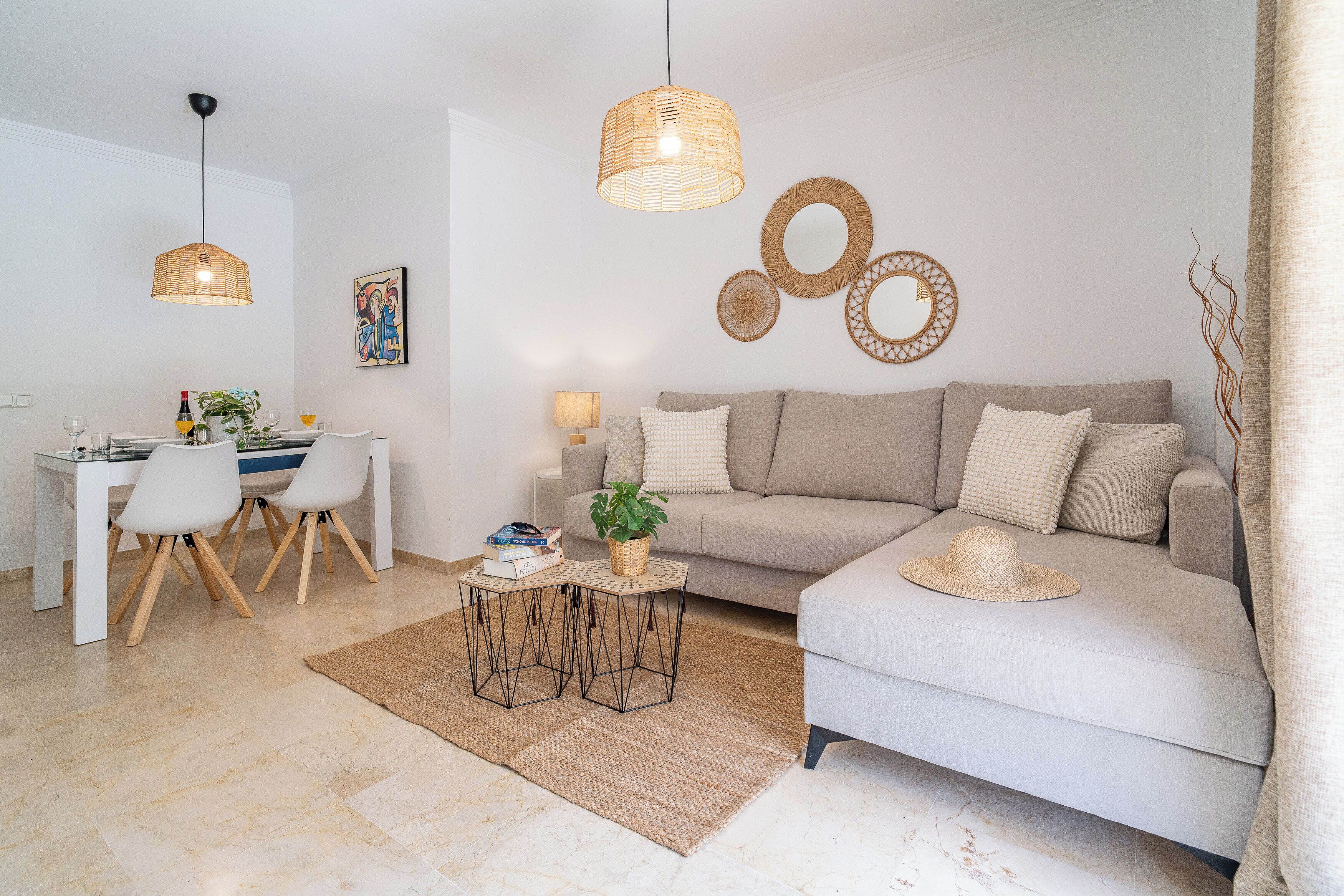 A modern living room with a sofa, dining table, chairs, and decorative wall art.