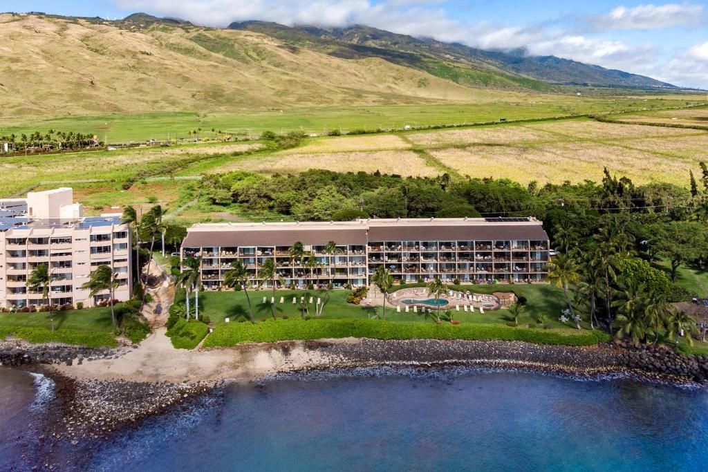 A resort with multiple buildings, a pool area, and a beachfront.