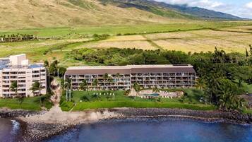 A resort with multiple buildings, a pool area, and a beachfront.