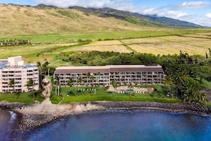 Un complexe hôtelier comprenant plusieurs bâtiments, un espace piscine et un accès direct à la plage.