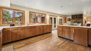 Una cocina amplia con armarios de madera, ventanas grandes y vistas al exterior.
