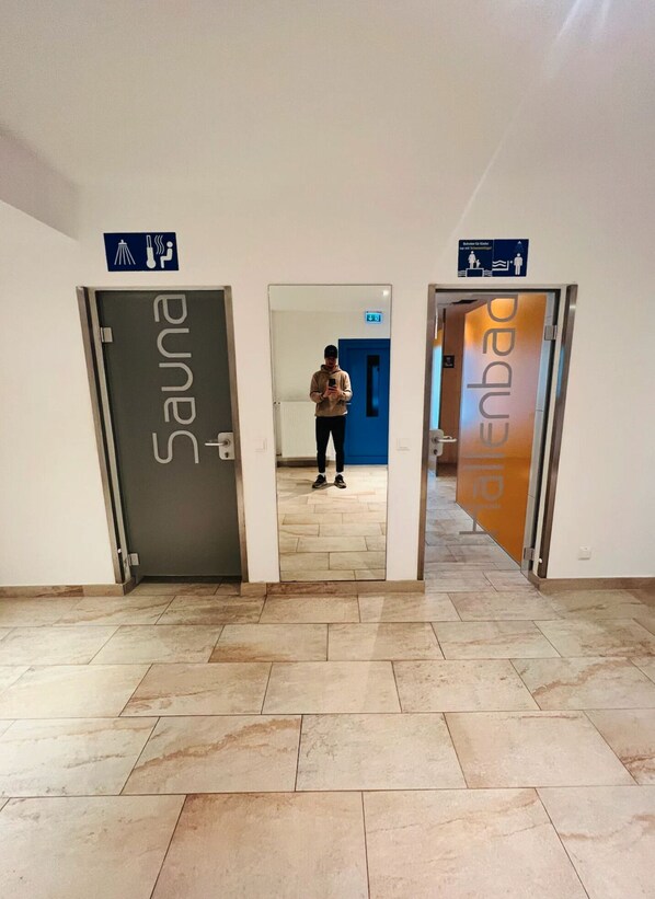 Un pasillo con puertas que indican “Sauna” y “Enbar.”