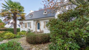 A white house with a stone facade, a blue door, and a stone pathway leading to the entrance. - Ty Bigorn'oh - Three Bedroom House, Sleeps 7 (Benodet)