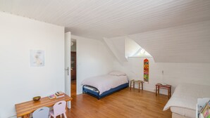 A bedroom with a sloped ceiling, a bed, a desk with chairs, and a small table. - Ty Bigorn'oh - Three Bedroom House, Sleeps 7 (Benodet)