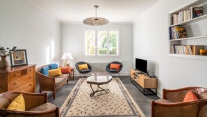 A living room with a sofa, two armchairs, a coffee table, a bookshelf, a television, and a radiator. - Ty Bigorn'oh - Three Bedroom House, Sleeps 7 (Benodet)