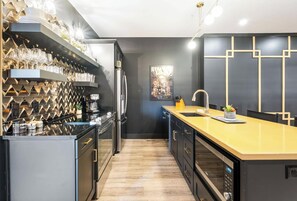 A modern kitchen with a central island, built-in appliances, and a decorative wall.