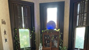 Een eetkamer met een tafel gedekt voor vier personen, houten vloeren en een kast met glazen deuren.