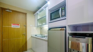 A compact kitchen with a microwave, refrigerator, and sink.