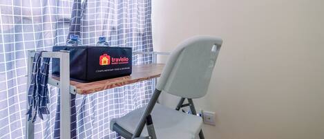A traveler's desk with a bag labeled "Travelio" and a chair.