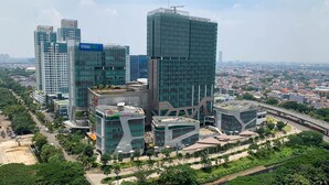 A modern urban area with high-rise buildings, including a prominent one with a sign reading "KIRANATHREE". - Cozy And Tidy Studio At Tifolia Apartment (Jakarta)