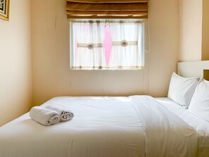 Relax in comfort with a neatly made bed and a serene atmosphere.