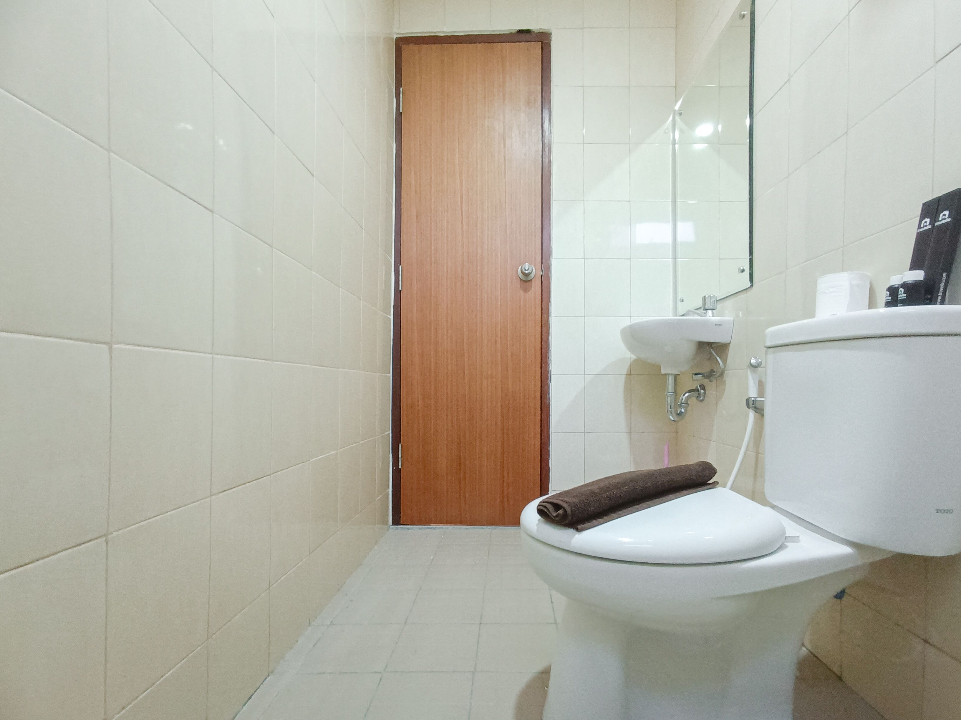 Un baño pequeño con inodoro, lavamanos y espejo.