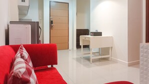 Uma sala de estar moderna com um sofá vermelho, uma mesa branca e uma porta de madeira.