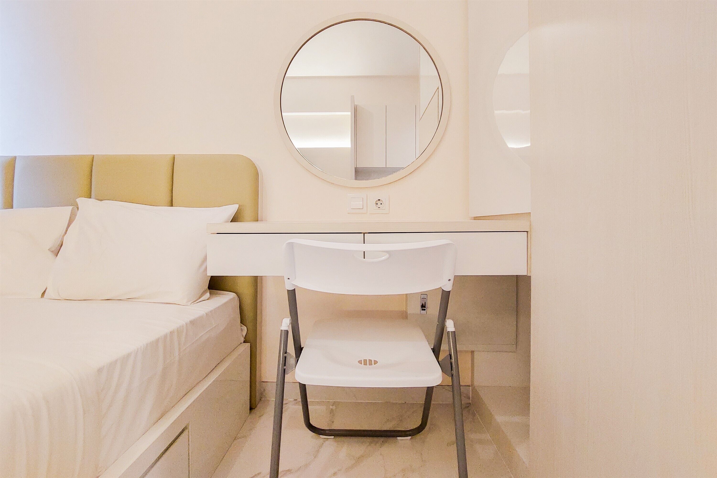A bedroom with a bed, a desk, and a chair.