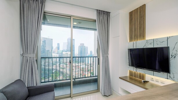 Un salon moderne doté d’une grande fenêtre, d’un téléviseur à écran plat et d’un mur décoratif en bois.