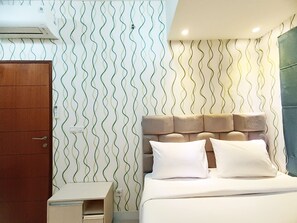 Cozy retreat with a comfortable bed, wavy patterned wall, and a stylish wardrobe.
