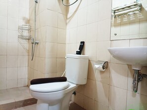 Bathroom features a toilet, shower, and sink with a simple design.