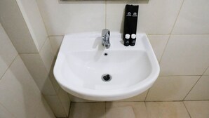 A white bathroom sink with a chrome faucet, a towel rack with two towels, and a mirror above. - Comfy And Modern Studio (No Kitchen) At Orchard Supermall Mansion Apartment (Surabaya)