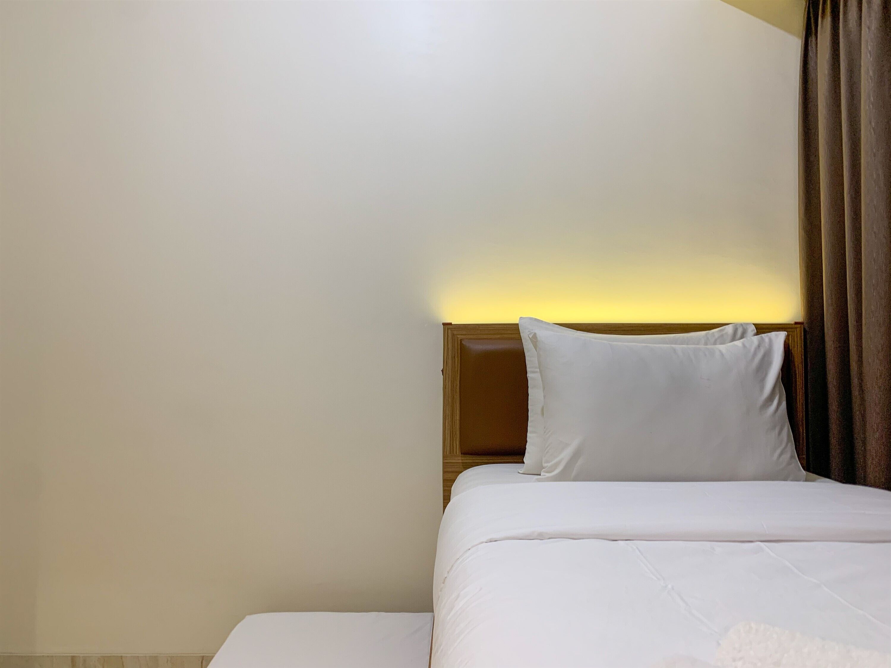 Une chambre d’hôtel avec un lit, une table de chevet et une lampe.