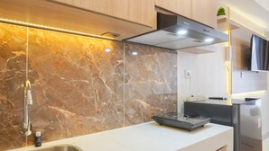 A modern kitchen with marble backsplash, stainless steel appliances, and a built-in oven.