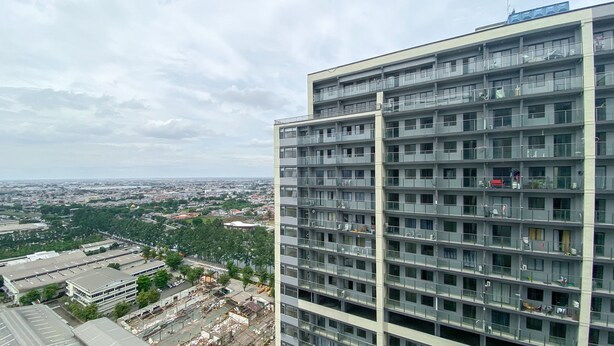 Un edificio de varios pisos con un diseño arquitectónico moderno, que incluye balcones y ventanas amplias.