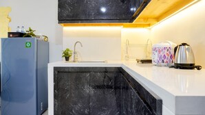 A modern kitchen with a marble countertop, a built-in sink, and a stainless steel kettle. - Nice And Comfort 2Br At Daan Mogot City Apartment (Jakarta)