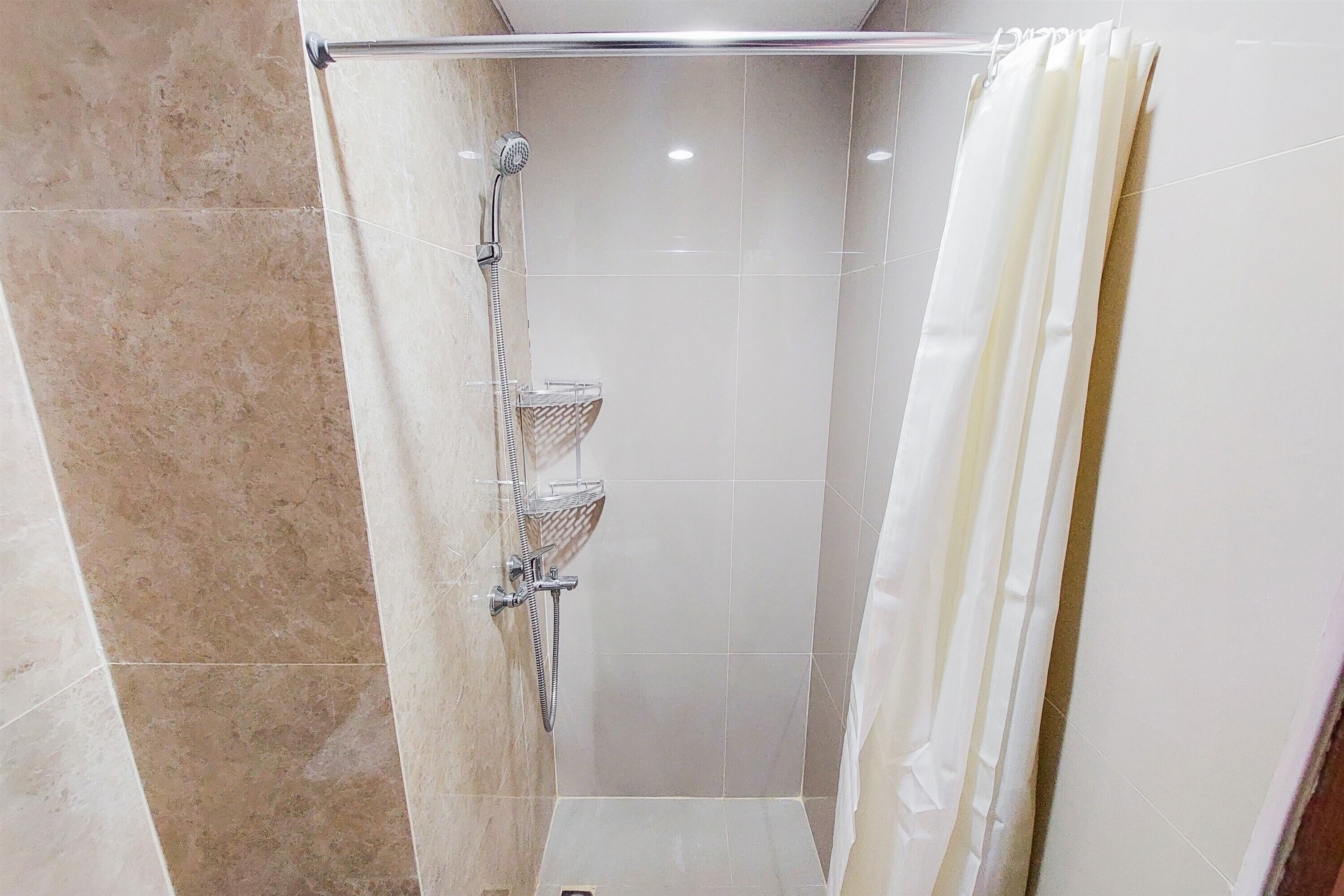 Un espace douche doté d’une porte en verre, d’un pommeau de douche et d’un porte-serviettes.