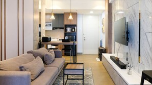 Ein modernes Wohnzimmer mit einer Couch, einem Couchtisch und einem an der Wand montierten Fernseher.