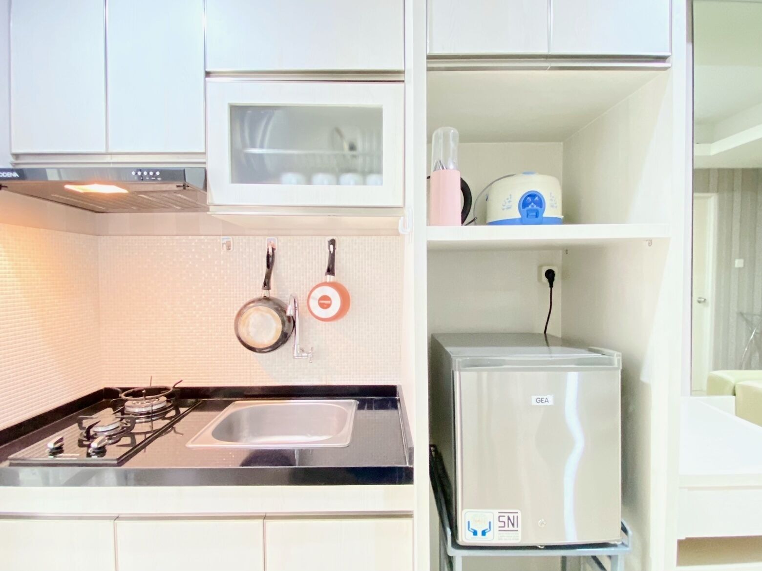 Une cuisine de taille réduite équipée d’une cuisinière à gaz, d’un évier et d’un four à micro-ondes.