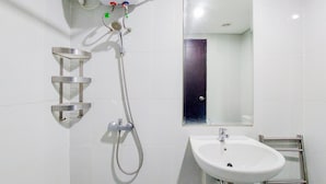 A bathroom with a shower, a sink, and a mirror. - Warm And Homey Studio Room Casa De Parco Apartment (South Tangerang)