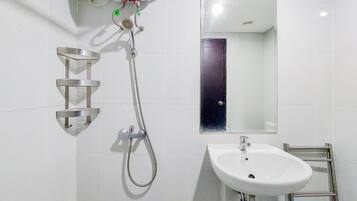 A bathroom with a shower, a sink, and a mirror.