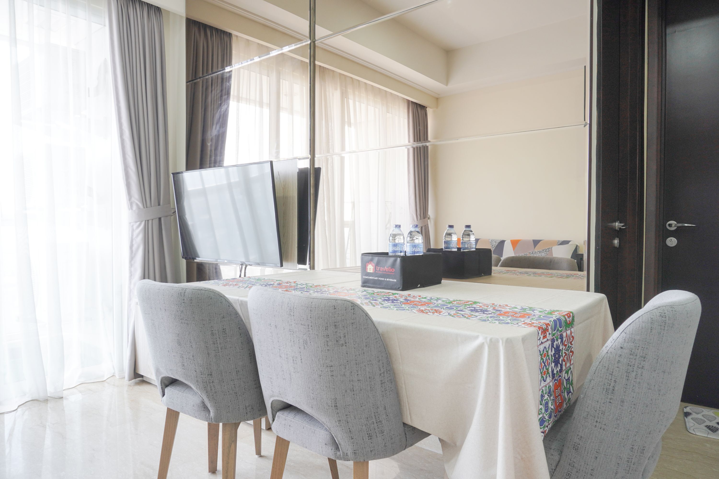 Une chambre d’hôtel équipée d’une table à manger, de quatre chaises, d’un téléviseur à écran plat, d’un minibar et d’un lit donnant sur une vue agréable.