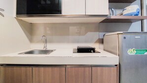 Een moderne keuken met een roestvrijstalen spoelbak, houten kastjes en een inbouwoven.