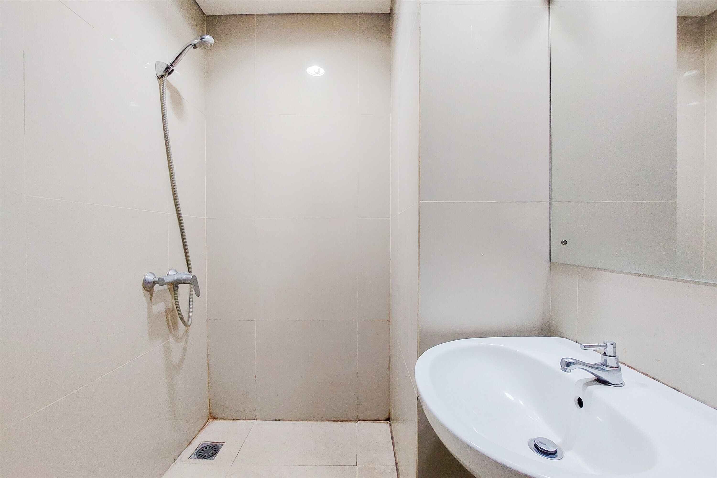 A bathroom with a shower, sink, and mirror.
