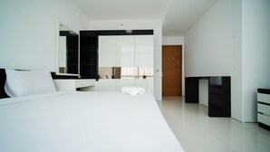 A modern hotel room with a large bed, a wardrobe, a mirror, and a door.
