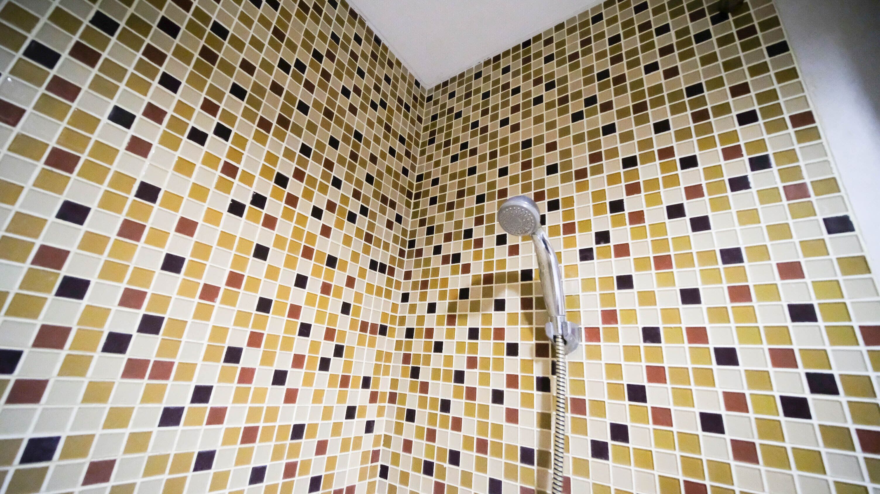 Un baño con pared de azulejos con un diseño geométrico.