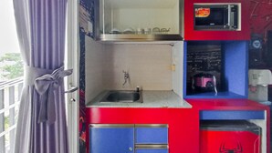 A compact kitchen with a sink, a microwave, and a small refrigerator.