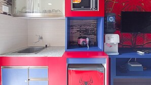 A compact kitchen with a sink, a microwave, a water dispenser, and a refrigerator.