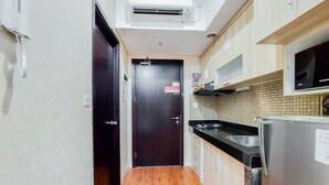 Una cucina piccola con un piano di lavoro in legno, un frigorifero in acciaio inossidabile e un forno a microonde.